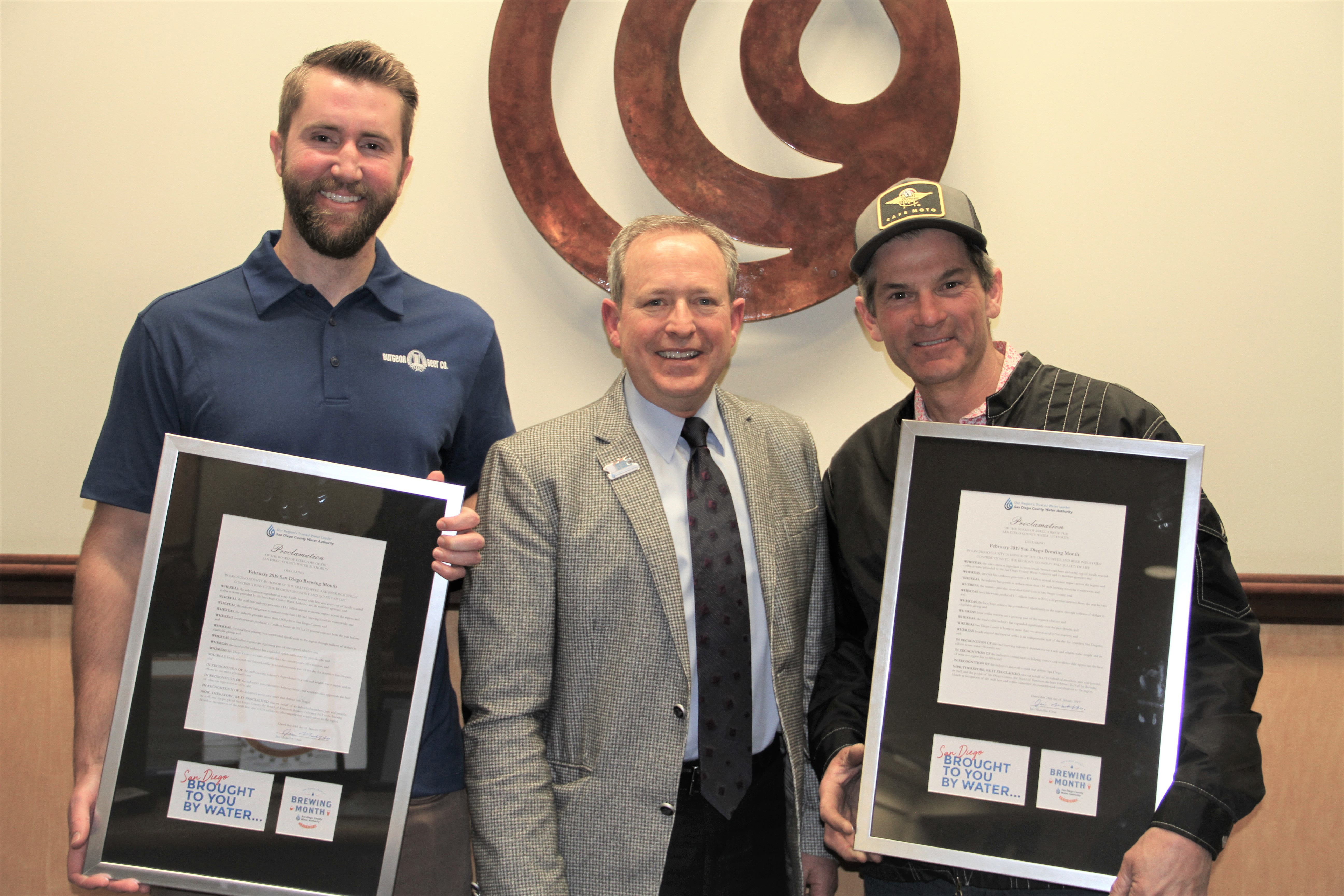 Three men standing in front of SDCWA logo.