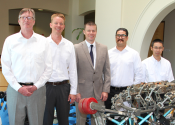 Five men standing in line in front of new technological developments for protecting the region’s water infrastructure.