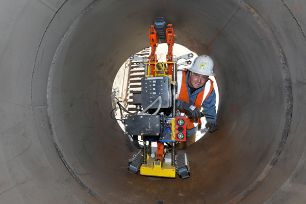 employee metering the inside of a pipeline